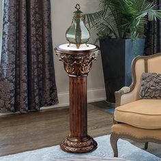 a lamp is sitting on top of a pedestal in the middle of a living room