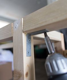 a close up of a wooden table with a metal object on the top and bottom