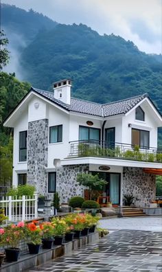 a large white house sitting on top of a lush green hillside