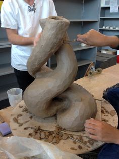 two men working on a sculpture in a studio