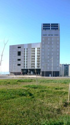 an empty field in front of a large building