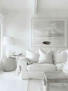 black and white photograph of a living room with couch, coffee table and painting on the wall