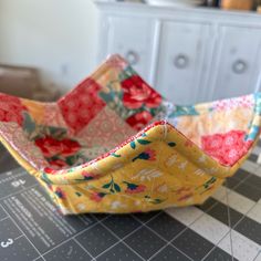 an empty bowl sitting on top of a table next to a cabinet and countertop