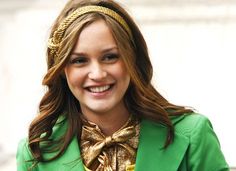 a woman wearing a green jacket and gold bow tie