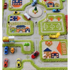 a child's play area with cars, trucks and houses on the rugs