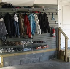 the inside of a garage with lots of clothes and shoes hanging on the wall next to it