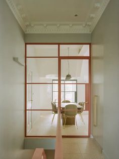 an empty room with glass walls and chairs