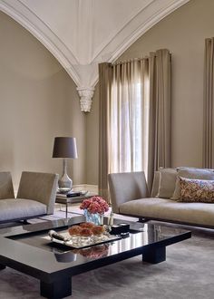 a living room with couches, chairs and a coffee table in front of a window