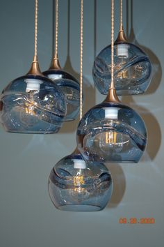 four glass lights hanging from the ceiling in a room