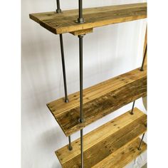 three shelves made out of wooden planks with metal rods on the bottom and sides