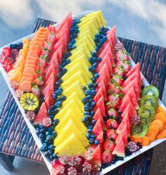 a platter filled with sliced fruit on top of a table