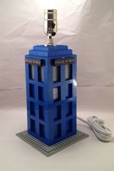 a lamp made out of legos on a white surface with a light plugged in