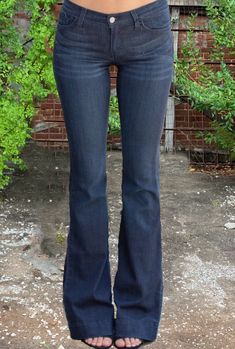 Vintage meets modern in these Judy Blue Fitted Trouser Jeans. With subtle bell-bottom appeal, these dark wash jeans feature a fitted thigh, floor-length flared leg, and 2” ankle hem. Classic 5-pocket design with zipper fly and button closure. Fits true to size Flare leg fit. 34” inseam Unlined. 59% Rayon, 23% Cotton, 17% Polyester, 1% Spandex Machine wash cold inside out/tumble dry low Made in USA. Dark Blue Bell Bottom Jeans, Dark Blue Flare Jeans, Skirt Over Jeans, Dark Flare Jeans, Trip List, Blue Flared Jeans, Vintage Flare Jeans, Vintage Meets Modern, Bootleg Jeans