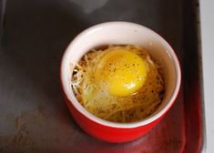 an egg is in a red cup on a tray