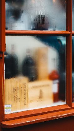 an old window with bottles in it and rain coming through the glass on the outside