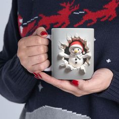 a woman holding a coffee mug with a snowman on it