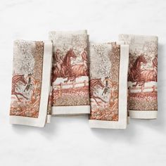 three napkins with horses on them sitting next to each other in front of a white wall