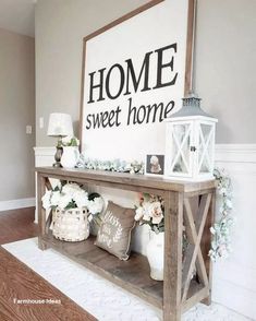 a wooden table topped with white flowers next to a sign that says home sweet home