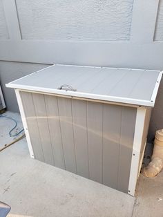 an outdoor storage shed is shown in front of a garage door with the doors open