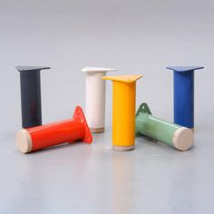 four different colored plastic objects sitting on the floor next to each other, including one with a toothbrush holder