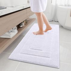 a person standing on a bath mat in a bathroom