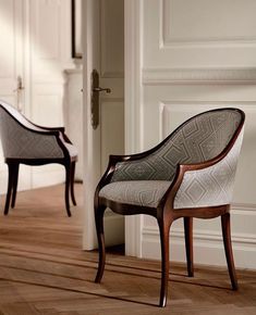 two chairs sitting next to each other on top of a hard wood floored floor