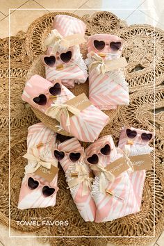 pink and white baby shower favors on a wicker tray with tags that read, towel favors