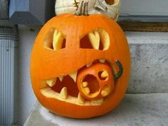 a carved pumpkin with its mouth open on the steps