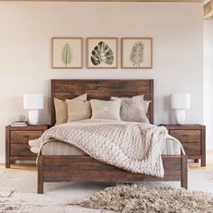 a bedroom with a bed, nightstands and two paintings on the wall above it