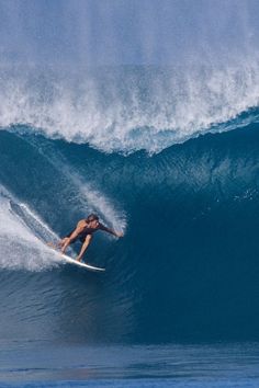 a man riding a wave on top of a surfboard