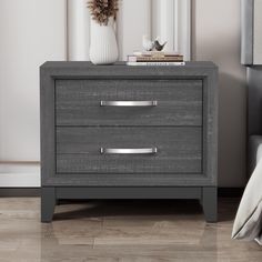 a gray nightstand with two drawers and a white vase on it's side table