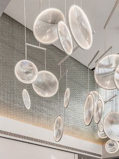 a room filled with lots of white plates hanging from the ceiling