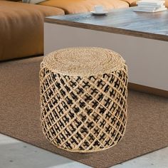 a coffee table that is made out of wicker and sits on the floor in front of a couch