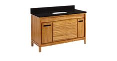 a bathroom vanity with black counter top and wooden cabinet doors on one side, two drawers on the other