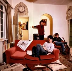 two people sitting on a red couch in a living room