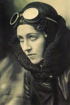 an old photo of a woman wearing a helmet and scarf with goggles on her head