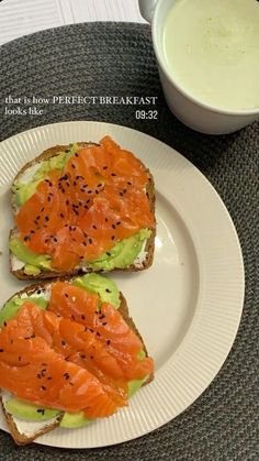 two pieces of toast with salmon and avocado on them next to a bowl of yogurt