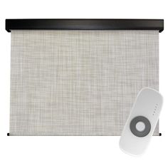 a remote control sitting on top of a blind in front of a white backdrop with black trim