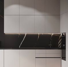 a kitchen with white cabinets and black counter tops, along with marble backsplash