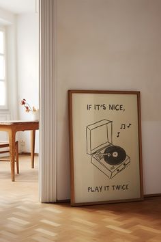 an old record player is on the floor next to a framed poster that says if it's nice, play it twice