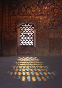 the sun is shining through a window in an old building with mosaic tiles on it