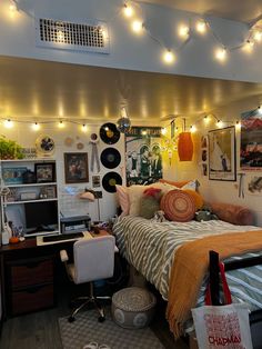 a bed room with a neatly made bed and lots of lights hanging from the ceiling