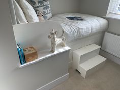 a white bed sitting next to a window in a room with two teddy bears on top of it