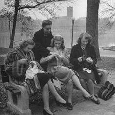 an old black and white photo of people sitting on the ground in front of a crowd