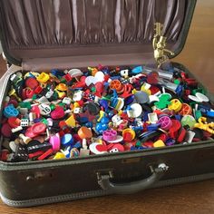 a suit case filled with lots of different types of buttons in it's lid