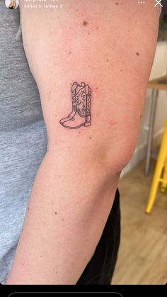 a woman's arm with a small tattoo of a cowboy boot on the side