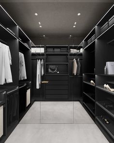 a black and white walk in closet with lots of clothes