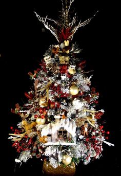 a decorated christmas tree with gold and red ornaments on it's top, in front of a black background