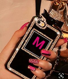 a woman's hand holding an iphone case with pink and black designs