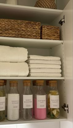 towels and bath products are on shelves in a bathroom closet, with baskets above them